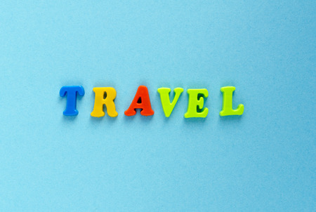 word "travel" of plastic magnetic letters on blue backgroundの写真素材