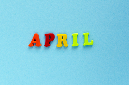 word "april" of plastic magnetic letters on blue backgroundの写真素材