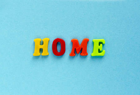 word "home" of plastic magnetic letters on blue backgroundの写真素材