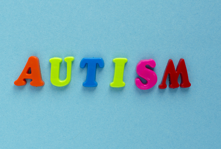 word "autism" of plastic magnetic letters on blue backgroundの写真素材