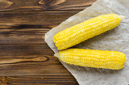 grilled corncob on wooden backgroundの写真素材