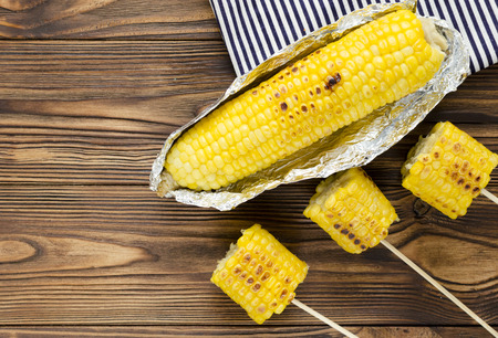 Grilled corncob on wooden backgroundの写真素材