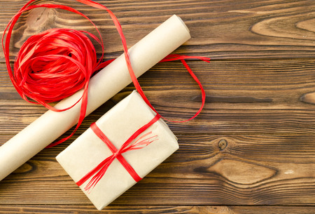 Red ribbon, craft paper on wooden background. packaging giftsの写真素材