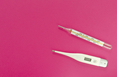 mercury and digital thermometers on pink backgroundの写真素材