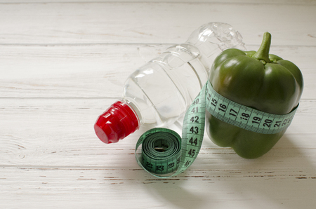 bottle of water, green  pepper, centimeter on white wooden background with space  for textの写真素材