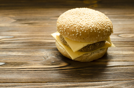 Cheeseburger on wooden background with space for textの写真素材