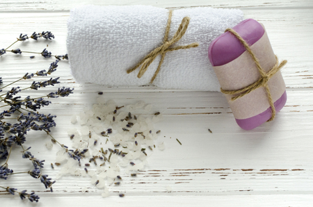 dry lavender flowers with soap, towel and sea salt on vintage wooden table. spa treatmentsの写真素材