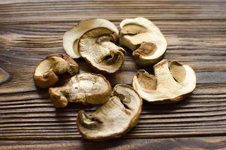 White dried mushrooms on wooden background ready for cooking の写真素材