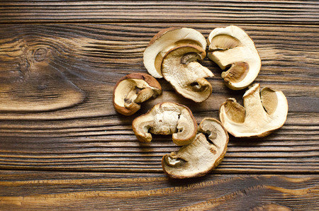 White dried mushrooms on wooden background ready for cooking の写真素材
