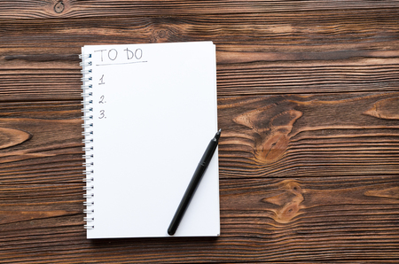 notepade with written phrase "to do list" and cup of coffee on wooden tableの写真素材