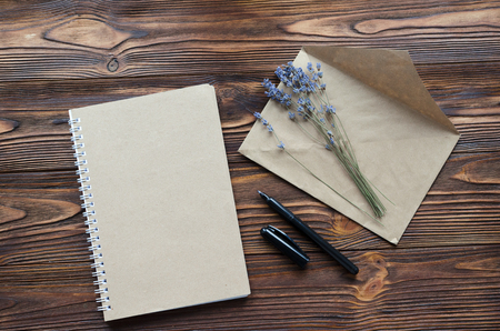 envelope, notepade from kraft paper, pen, dry lavender on wooden tableの写真素材