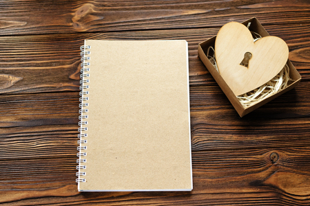 kraft paper notepade, wooden heart with key hole in gift boxの写真素材