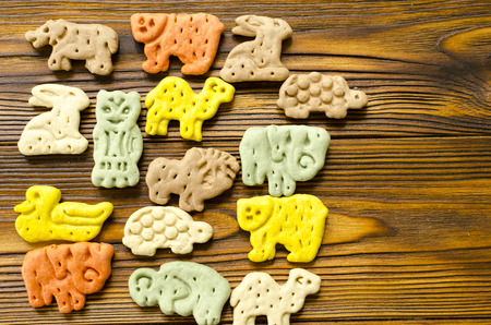 Delicious  colored zoological biscuits  for dogs with different tastes on wooden backgroundの写真素材