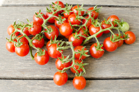 Cute cherry tomatoes on wooden background の写真素材