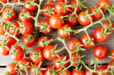 Cute cherry tomatoes on wooden background の写真素材