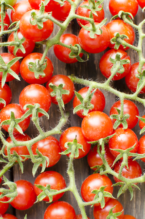 Cute cherry tomatoes on wooden background の写真素材
