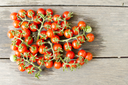 Cute cherry tomatoes on wooden background の写真素材