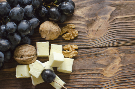 brie cheese with nuts and grape on wooden backgroundの写真素材