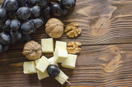 brie cheese with nuts and grape on wooden backgroundの写真素材