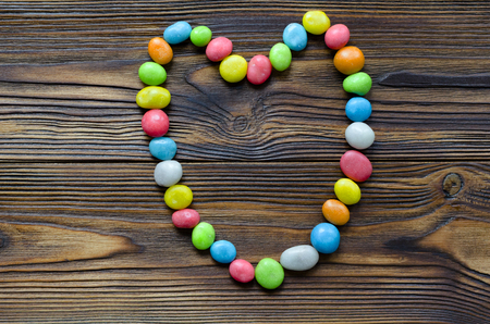 heart from multicolored candy on wooden backgroundの写真素材