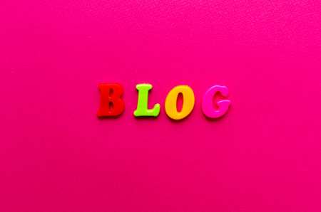 word 'blog' from plastic magnetic colored letters on pink paper backgroundの写真素材