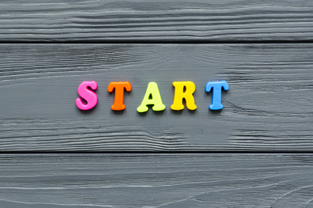 word "start" of colored plastic magnetic letters on grey wooden backgroundの写真素材
