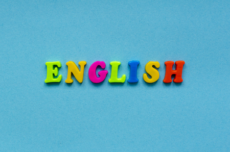 word "english" of colored plastic magnetic letters on blue paper backgroundの写真素材