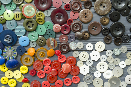 Colored plastic buttons on grey wooden backgroundの写真素材
