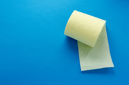 yellow toilet paper roll on blue backgroungの写真素材