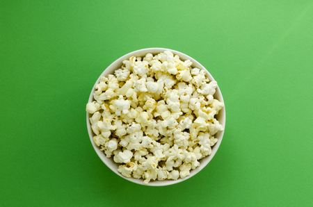 plate with popcorn on green paper backgroundの写真素材
