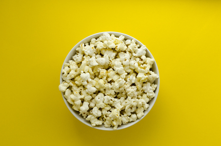 plate with popcorn  on yellow paper backgroundの写真素材