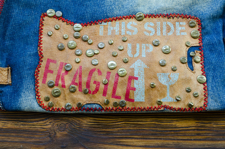 jeans denim with leather stripe and metal rivets on wooden tableの写真素材