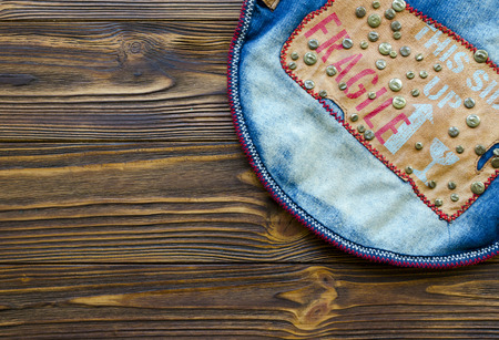 jeans denim with leather stripe and metal rivets on wooden tableの写真素材