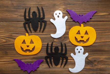 felt pumpkin, spider, ghost, bat on wooden backgroundの写真素材