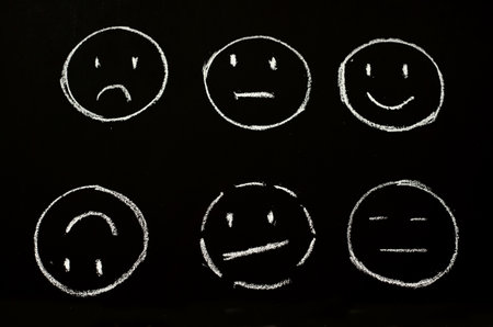 faces with different emotions drawn on chalkboardの写真素材