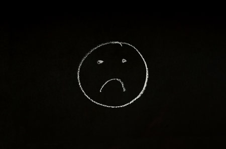 sad face drawn on chalkboardの写真素材