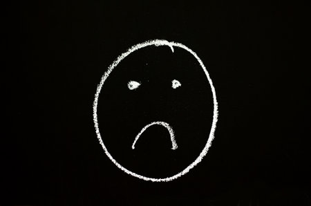 sad face drawn on chalkboardの写真素材