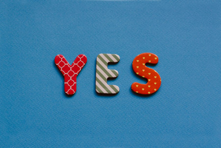 colored text yes on blue paper backgroundの写真素材