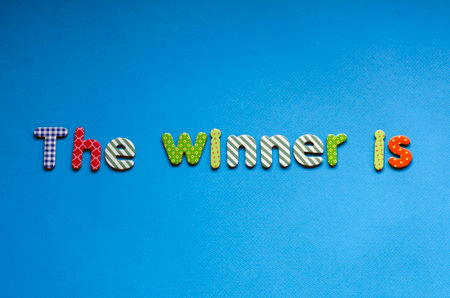 colored text the winner is on blue paper backgroundの写真素材
