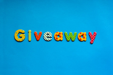 colored text giveaway on blue paper backgroundの写真素材