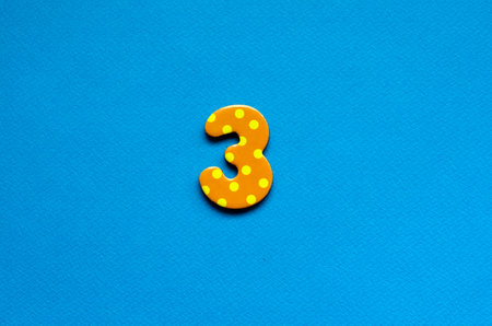 number three  on blue paper backgroundの写真素材