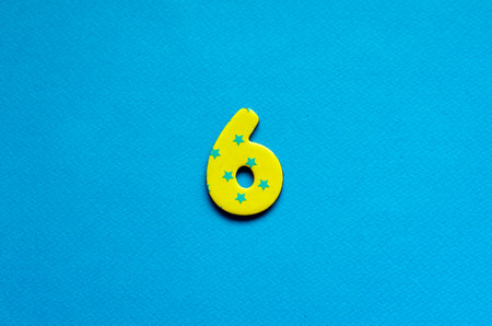 number six on blue paper backgroundの写真素材
