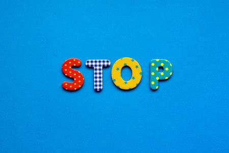 word stop from bright colored paper letters on blue paper backgroundの写真素材