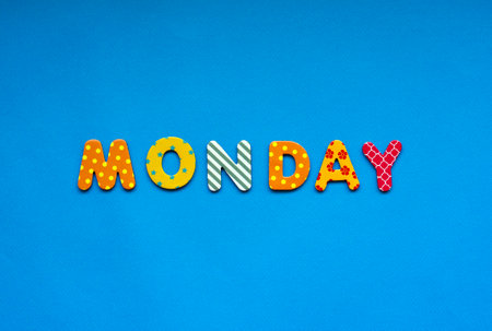 word Monday from bright colored paper letters on blue paper backgroundの写真素材