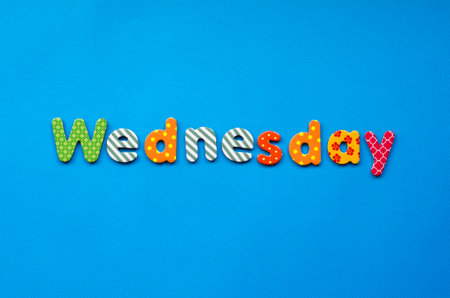 colored word Wednesday  on  blue paper backgroundの写真素材