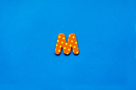 letter m on blue paper backgroundの写真素材