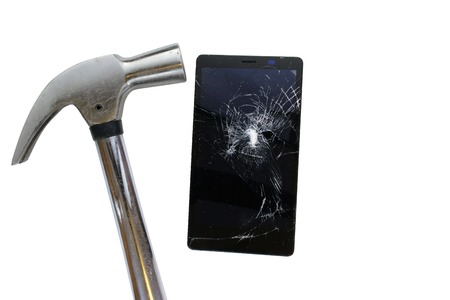 Hammer hit broken screen cell phone isolated on white background.の写真素材
