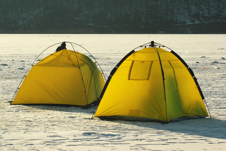 Two bright yellow tents of winter fishermen
