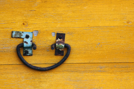 Rusty iron handle on old yellow wooden box