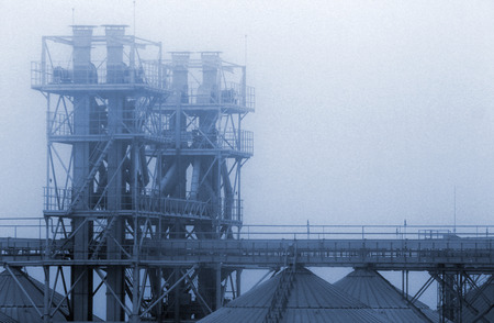 Grain terminal tanks in dense fog, Odessa, Ukraine. Industrial buildings in smog.の写真素材